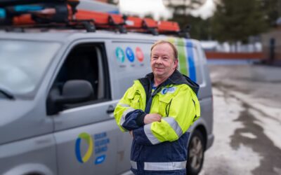 Oulun Seudun Sähkön mittariasentaja työasussa osuuskunnan auton edessä.