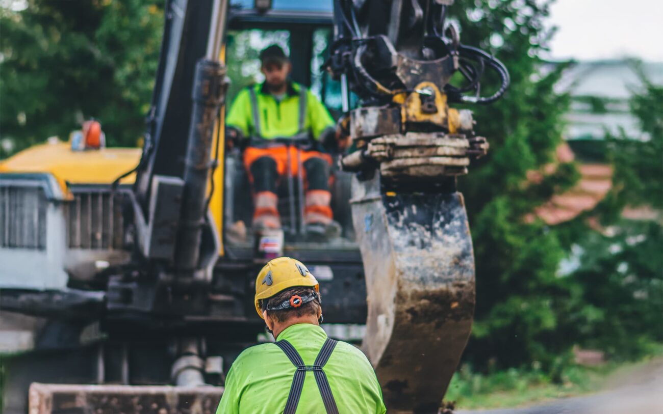Traktori tekemässä kaivuutöitä valokuitukaapelin asentamiseksi.