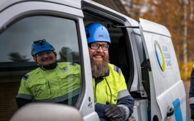 Mittarinvaihtoa kotitalouksille tekevät työntekijät työauton luona.